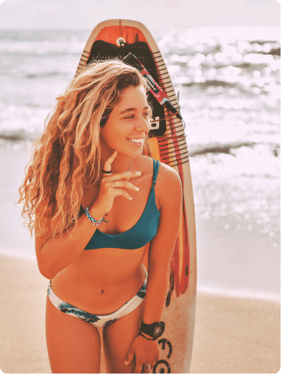 Mulher com prancha de surfe na praia